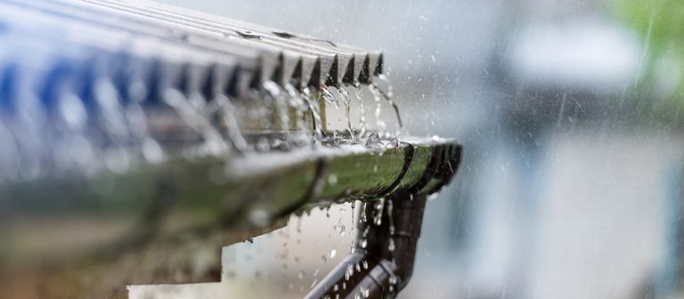 Rain flowing from a roof into guttering